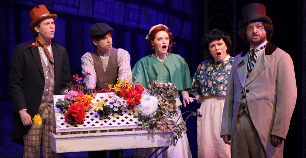group of actors in a London street standing around flower cart