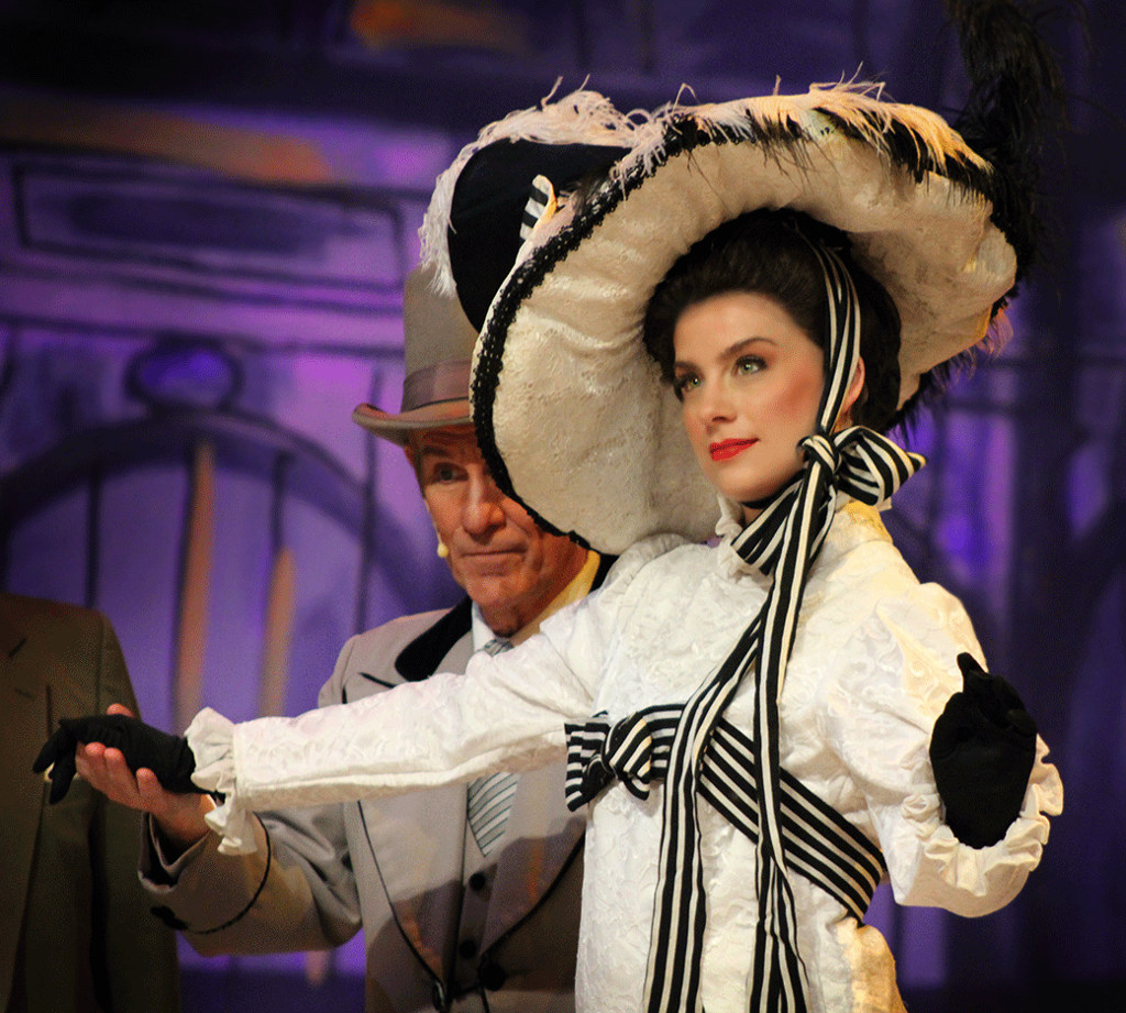 Actress playing Eliza Doolittle in black and white dress at the Ascot races
