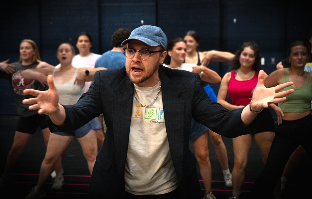and actor in a ball cap looking perplexed with his hand out