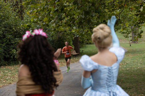 Photo of a runner coming towards princesses on a 5K path