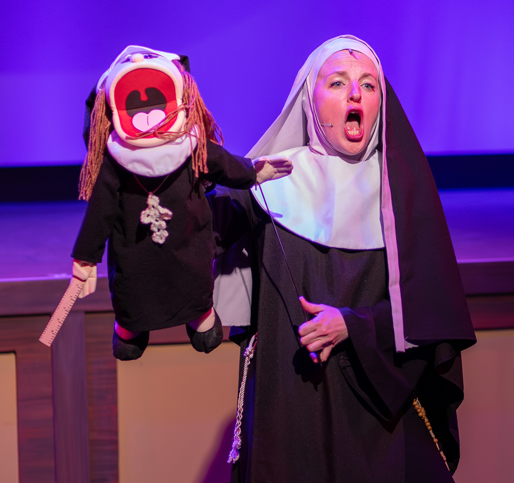 a funny picture of a nun singing while holding a puppet of a nun singing!